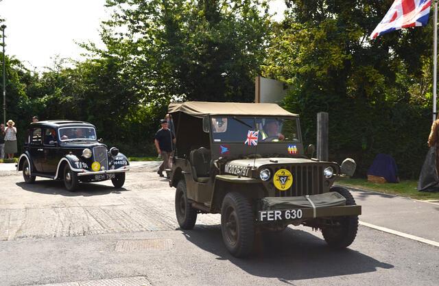 A wartime Jeep leads the Austin 10 Staff car