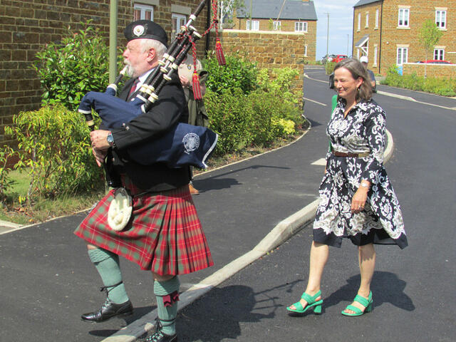 The piper leads Jo Eames to give her speech on Hobo's background